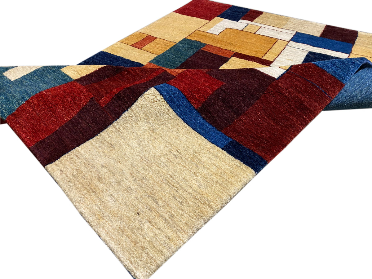 Gabbeh-Luri-Teppich ausgebreitet: geometrisches Muster aus Rot, Blau und Beige.