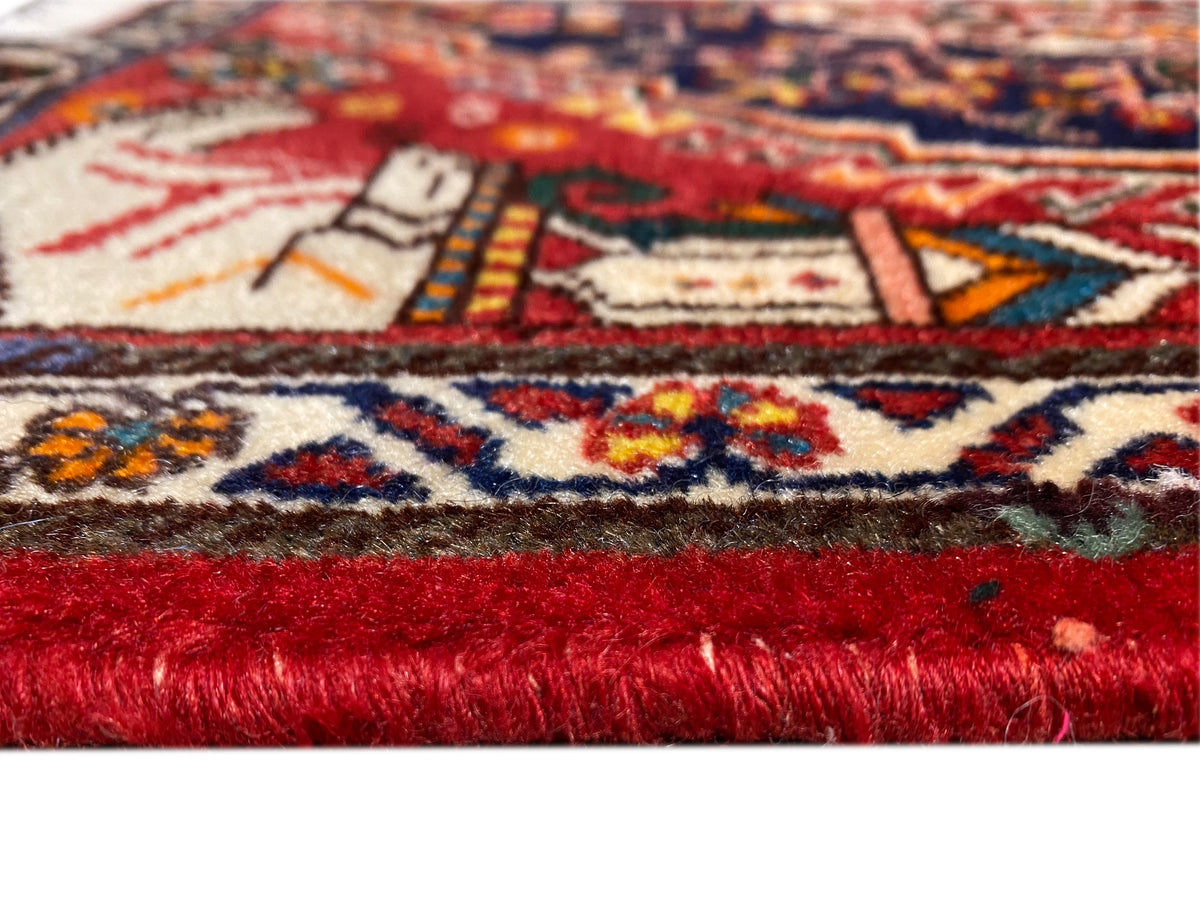 Detail des Teppichflors: roter Florstreifen und mehrfarbige Ornamente am Rand