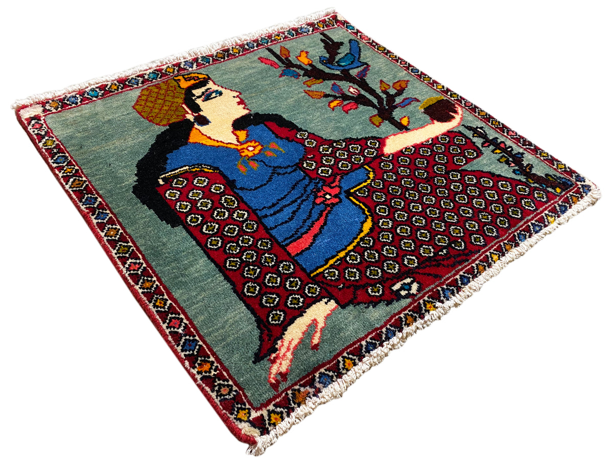 ポシュティのラグ 68x63 cm、斜め上から見た構図：木と人物のモチーフ、カラフルな縁取り、フリンジ