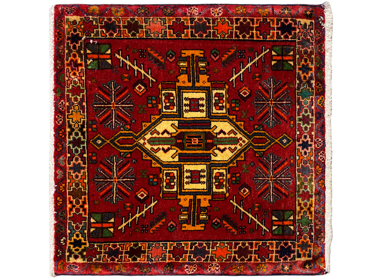 赤い背景に幾何学的な中央モチーフをあしらった、カラフルな長方形のポシュティラグ rug