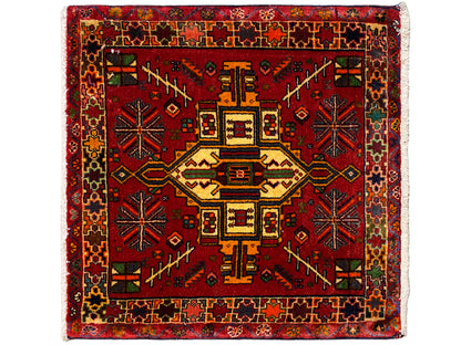 赤い背景に幾何学的な中央モチーフをあしらった、カラフルな長方形のポシュティラグ rug