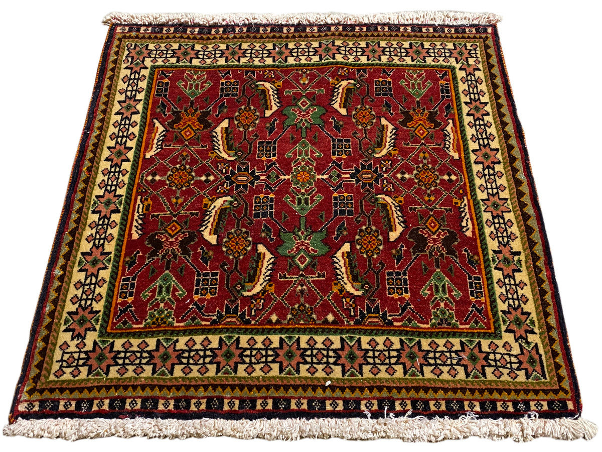 ポシュティ絨毯 63x61 cm、斜めから見た図：緑とベージュの中に赤いオーナメント模様。