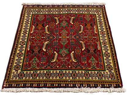 ポシュティ絨毯 63x61 cm、斜めから見た図：緑とベージュの中に赤いオーナメント模様。