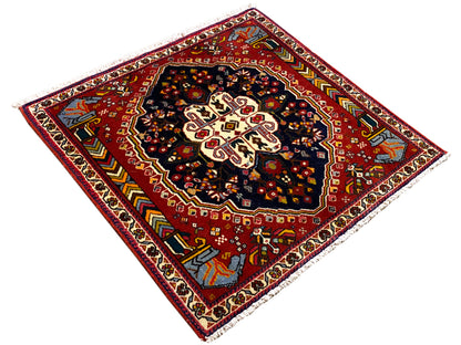 ポシュティ絨毯 65x61 cm、斜めから見た図：赤い背景に濃紺の中央部分