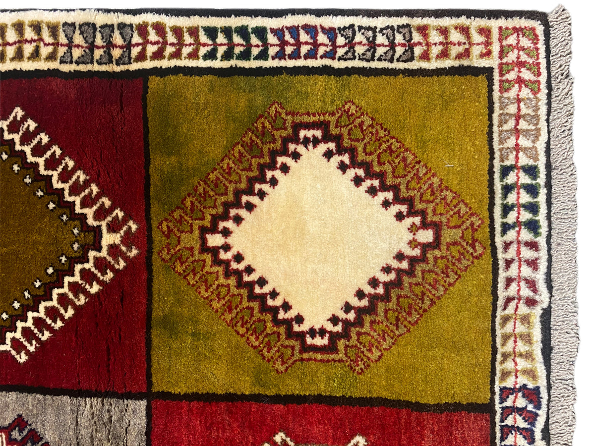 Detail vom Orientteppich: Rautenfeld in Rot, Grün und Gelb mit heller Zierkante